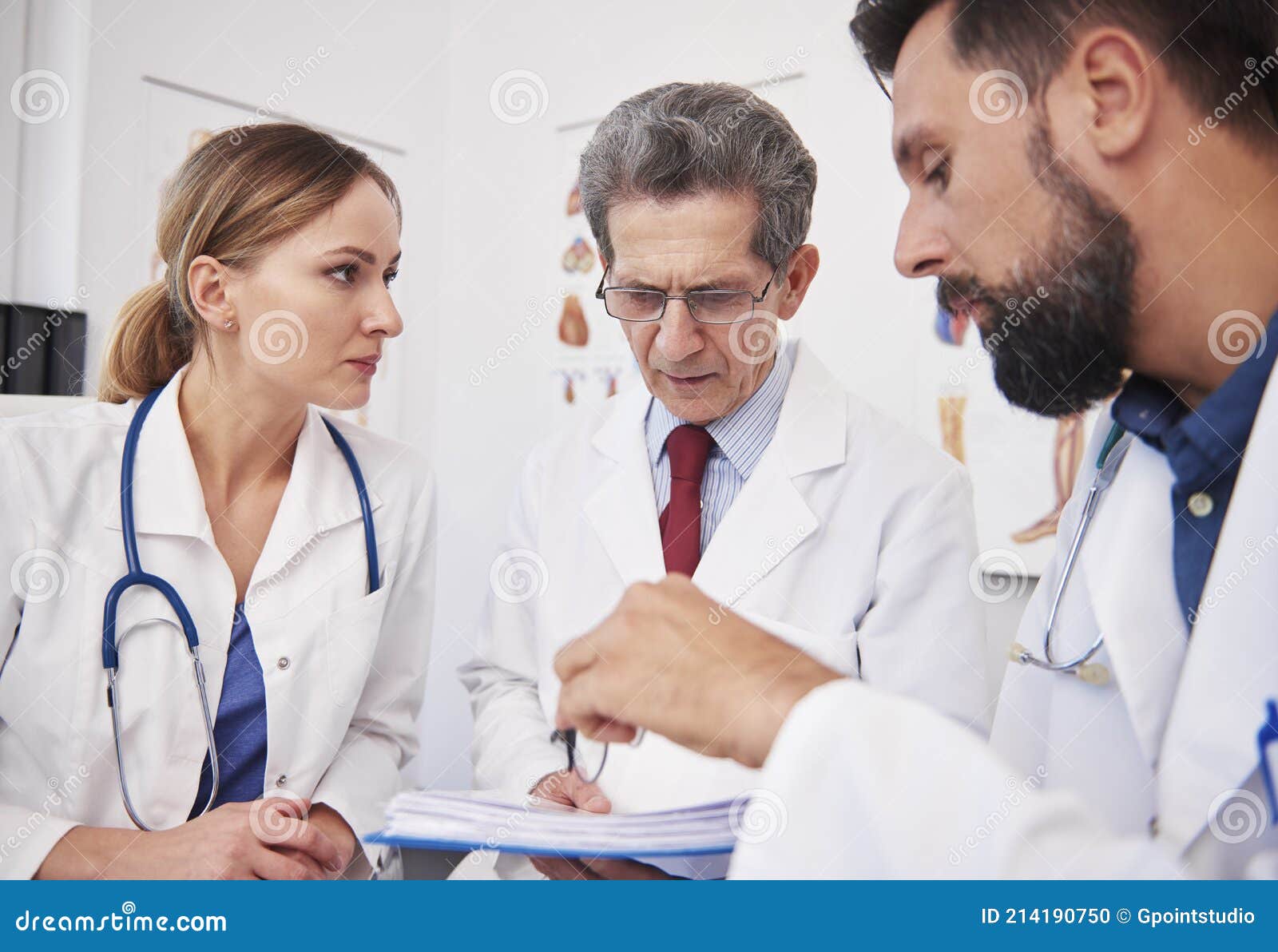 three doctors discussing medical records in doctorÃ¢â¬â¢s office